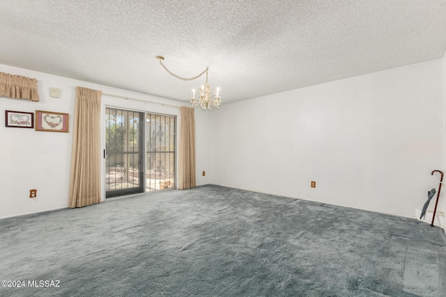 empty room featuring carpet floors, a textured ceiling, and an inviting chandelier