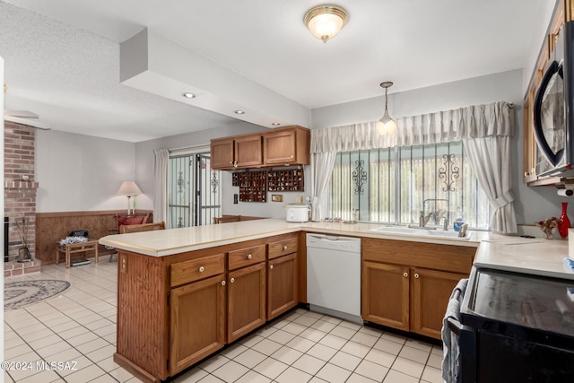 kitchen featuring dishwasher, sink, range with electric stovetop, kitchen peninsula, and decorative light fixtures