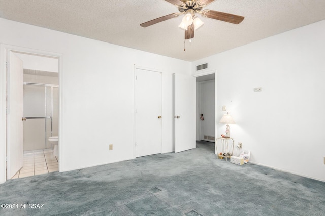 unfurnished bedroom featuring connected bathroom, ceiling fan, carpet floors, and a textured ceiling