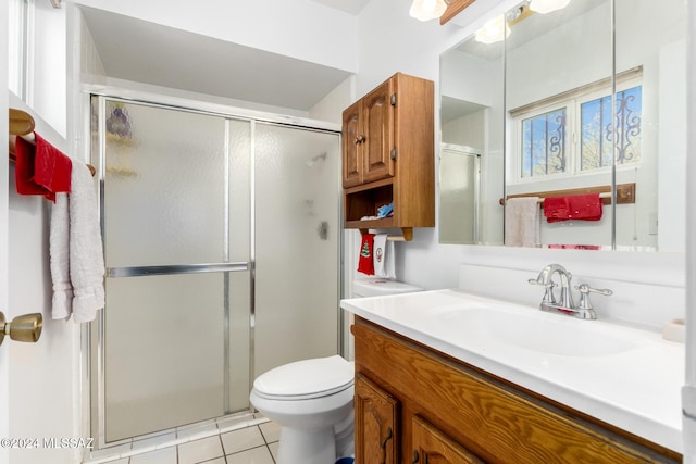 bathroom featuring toilet, a shower with door, vanity, and tile patterned flooring