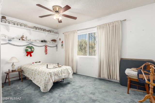 bedroom with ceiling fan, carpet, and a textured ceiling