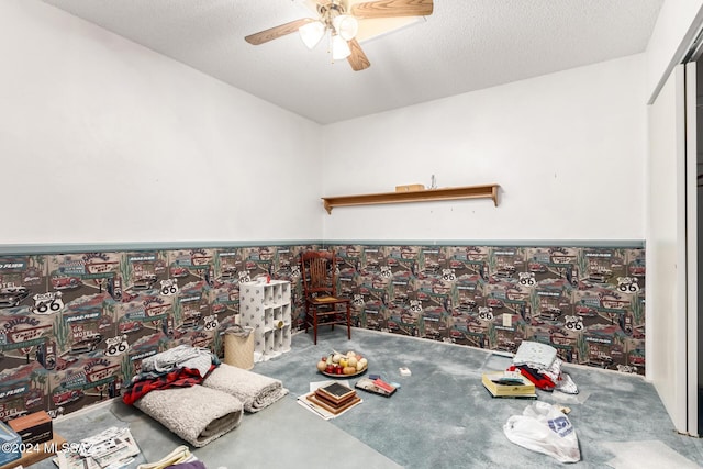 unfurnished dining area featuring ceiling fan and a textured ceiling