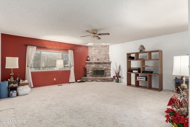 carpeted living room featuring ceiling fan, a textured ceiling, and a brick fireplace