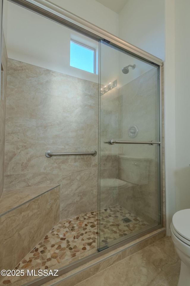 bathroom featuring toilet and an enclosed shower