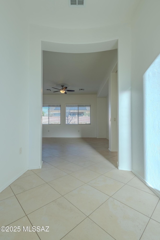 tiled empty room featuring ceiling fan