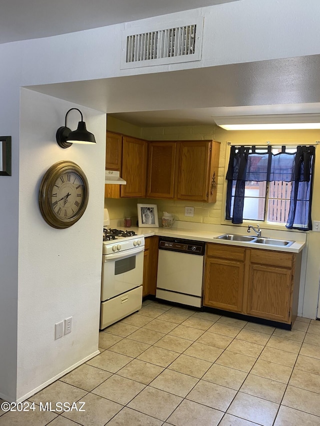 kitchen featuring light tile patterned floors, white appliances, and sink