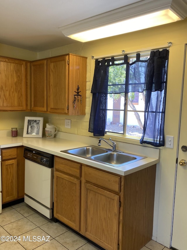 kitchen with white dishwasher, light tile patterned floors, and sink