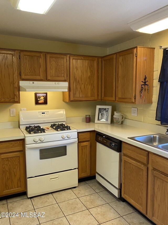 kitchen featuring white appliances, sink, and light tile patterned floors