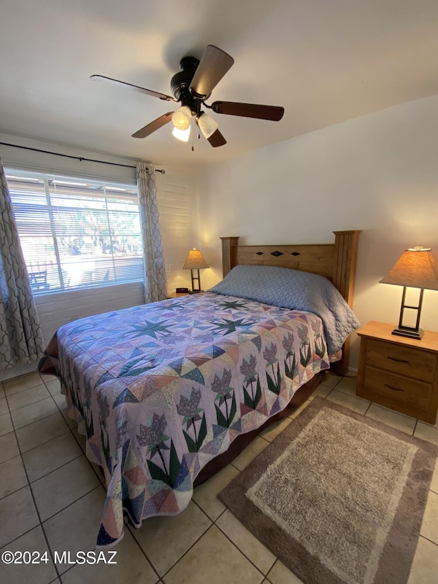 tiled bedroom featuring ceiling fan