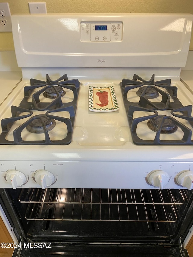 room details featuring white cabinetry and white range with gas cooktop