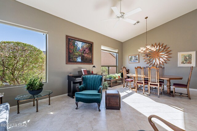 living room featuring ceiling fan with notable chandelier and vaulted ceiling