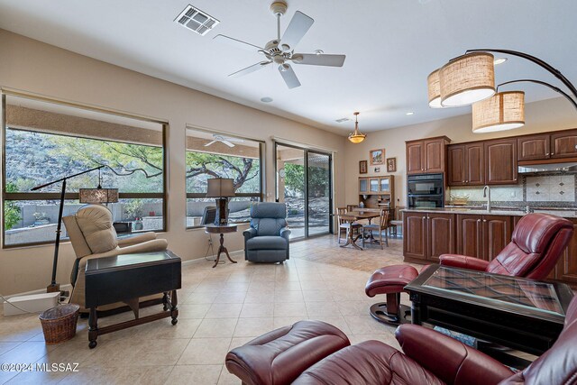 living room with ceiling fan, sink, and light tile patterned flooring