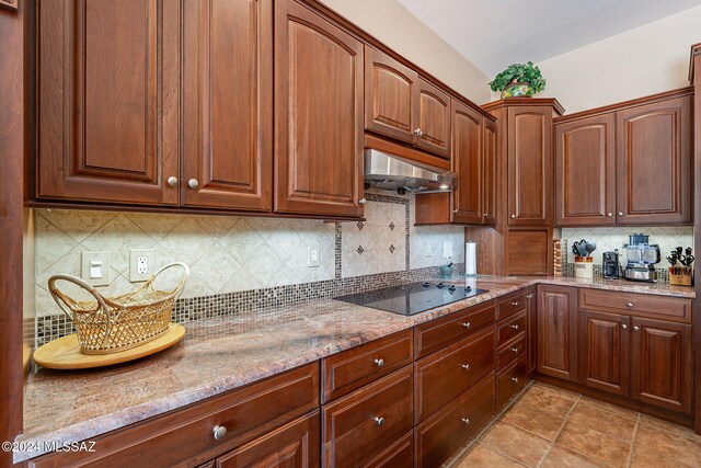 kitchen featuring decorative backsplash, extractor fan, sink, black appliances, and an island with sink