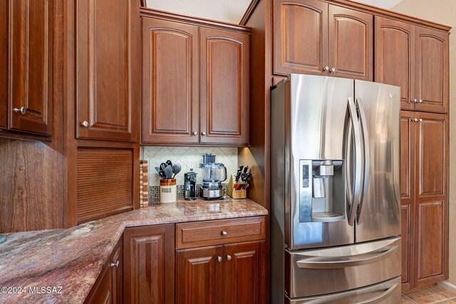 kitchen featuring backsplash, black electric cooktop, and light stone counters