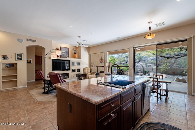 kitchen featuring pendant lighting, dishwasher, a center island with sink, sink, and ceiling fan