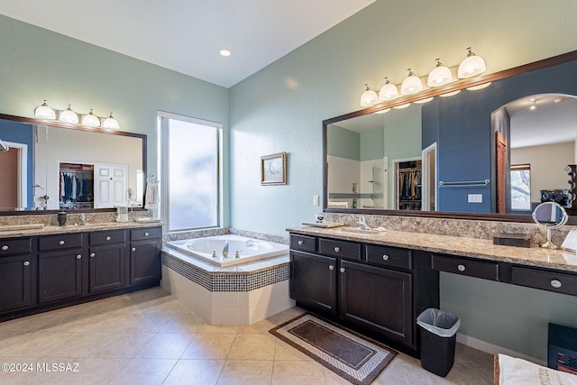 full bath with tile patterned flooring, vanity, a walk in closet, and a bath