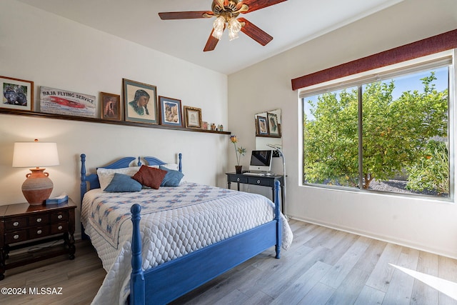 bedroom featuring baseboards, ceiling fan, and wood finished floors