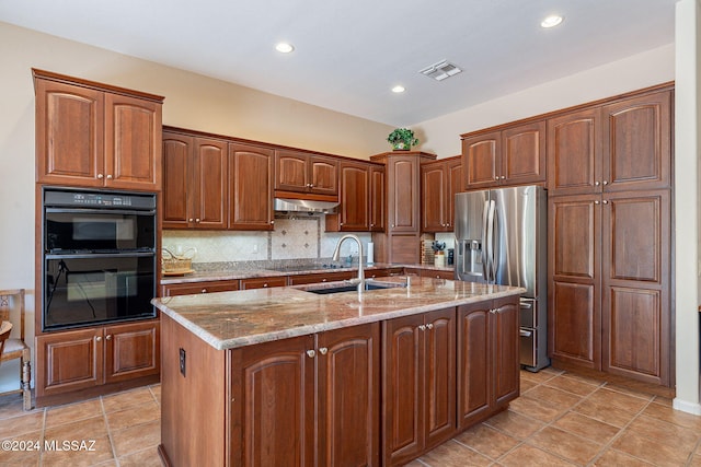kitchen featuring under cabinet range hood, backsplash, a sink, light stone countertops, and black appliances