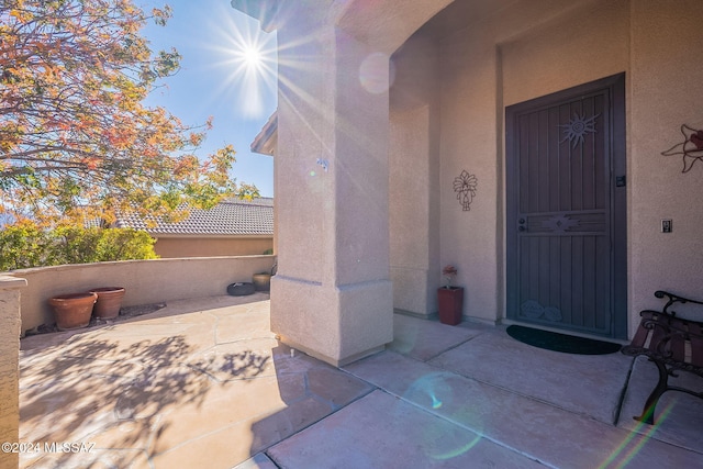 entrance to property featuring stucco siding and a patio
