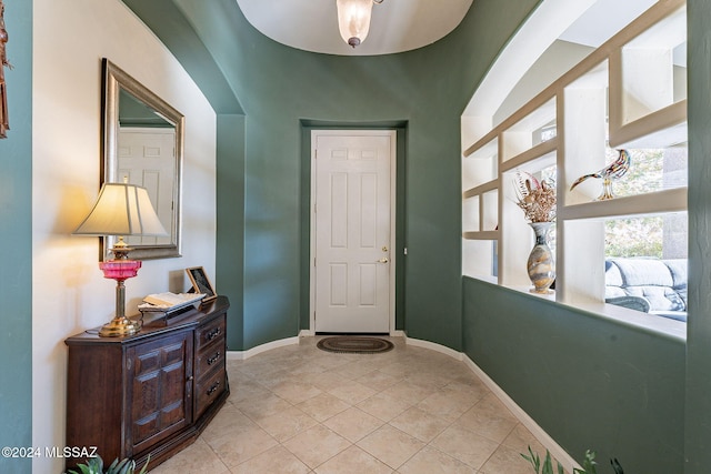 foyer featuring light tile patterned flooring and baseboards