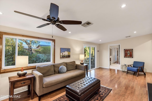 living room with light hardwood / wood-style flooring and ceiling fan