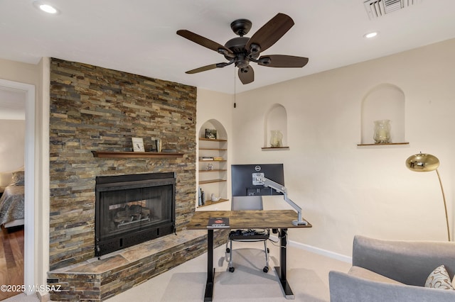 carpeted office space featuring ceiling fan, built in features, and a fireplace