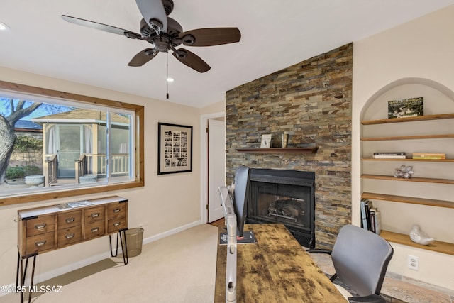 interior space with ceiling fan, a fireplace, light carpet, built in shelves, and vaulted ceiling