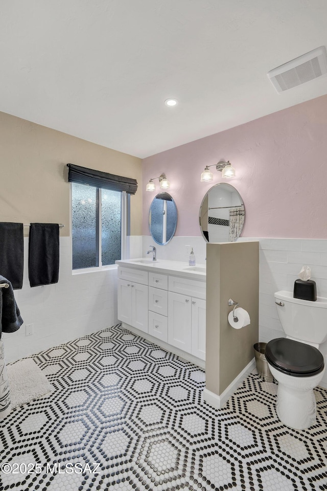 bathroom with tile patterned flooring, vanity, tile walls, and toilet