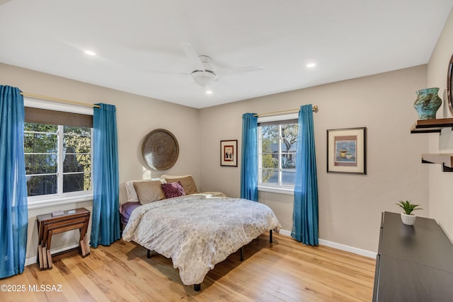 bedroom with multiple windows, light wood-type flooring, and ceiling fan