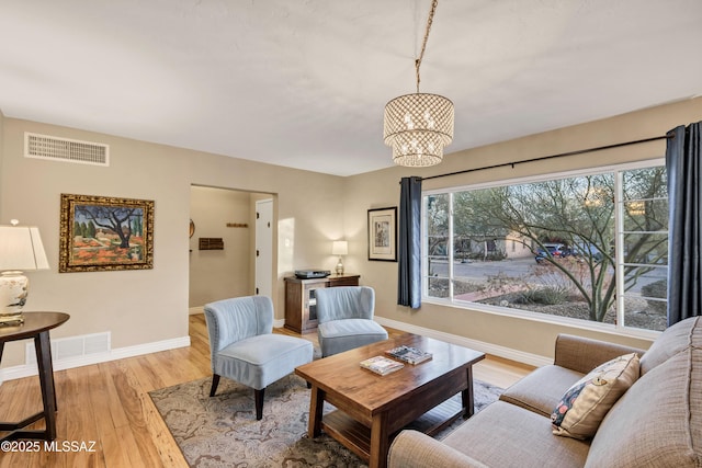 living room featuring an inviting chandelier and light hardwood / wood-style flooring