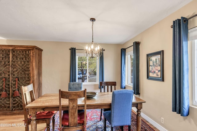 dining area with hardwood / wood-style flooring and a chandelier