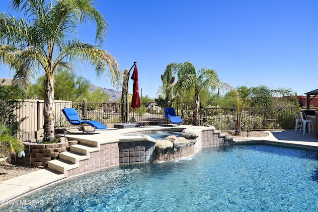 view of swimming pool with an in ground hot tub, a patio, and pool water feature