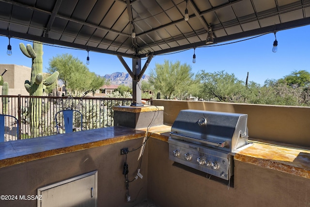 view of patio / terrace featuring a gazebo, a mountain view, area for grilling, and an outdoor kitchen