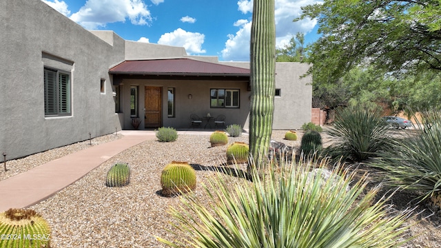 exterior space featuring metal roof and stucco siding