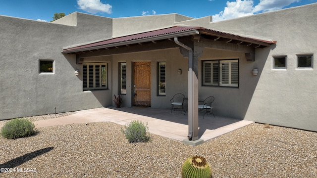rear view of house featuring a patio and stucco siding