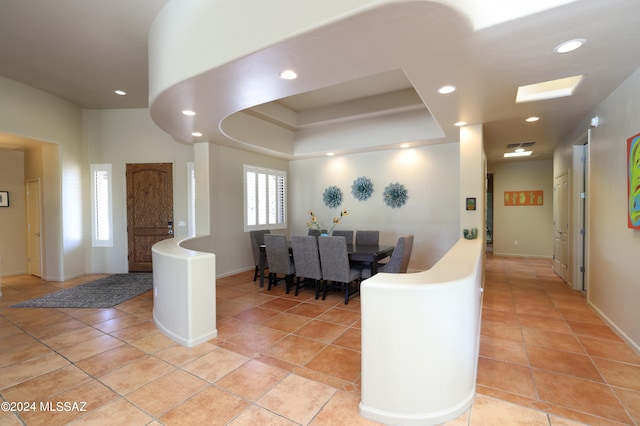 interior space featuring recessed lighting, baseboards, light tile patterned floors, and a tray ceiling