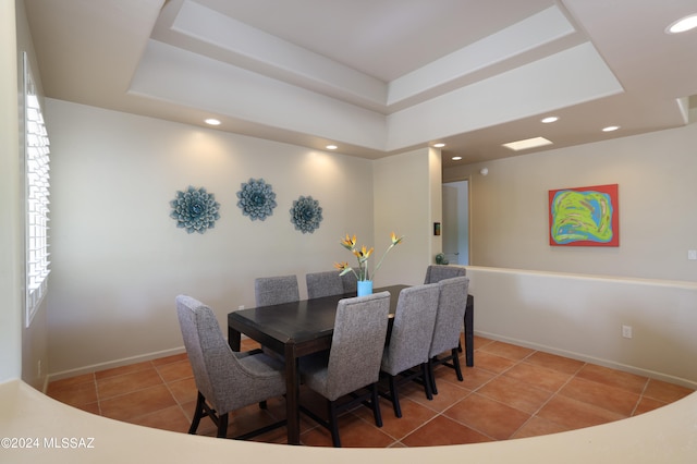 dining area with tile patterned flooring, a tray ceiling, and recessed lighting