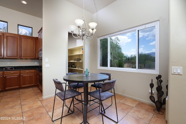 dining space featuring baseboards, light tile patterned flooring, a chandelier, and high vaulted ceiling