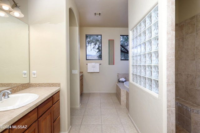 full bath with vanity, tile patterned flooring, a bathing tub, and visible vents