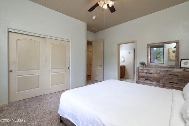 carpeted bedroom featuring a closet, connected bathroom, and ceiling fan