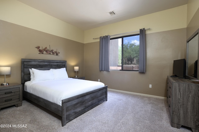 bedroom featuring visible vents, baseboards, and light carpet