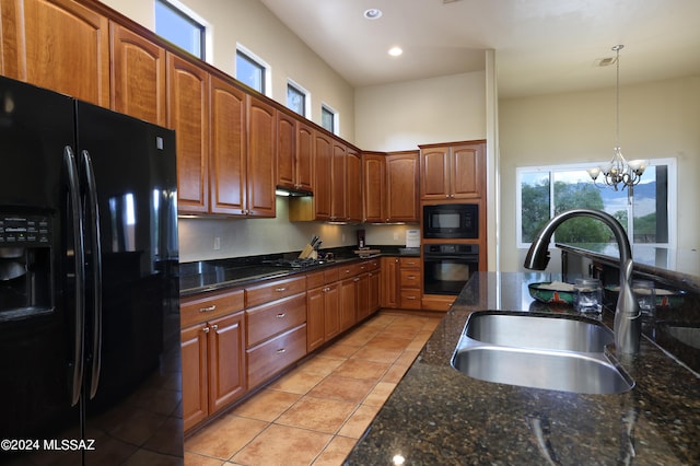 kitchen featuring a sink, black appliances, a notable chandelier, light tile patterned flooring, and a wealth of natural light