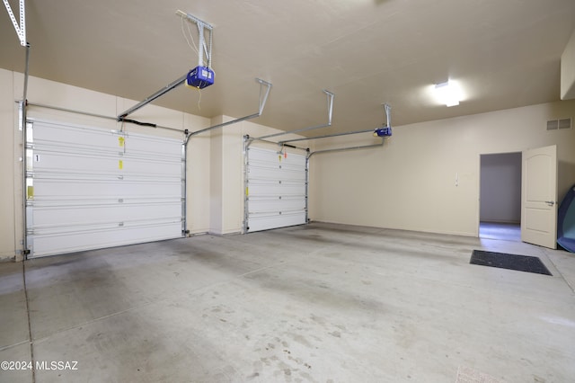 garage with a garage door opener and visible vents