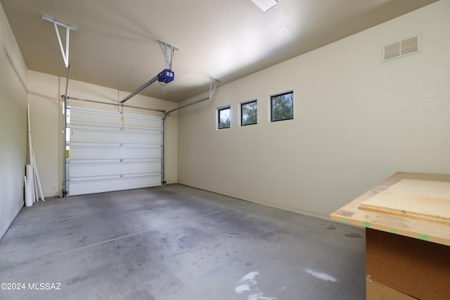 garage featuring a garage door opener and visible vents