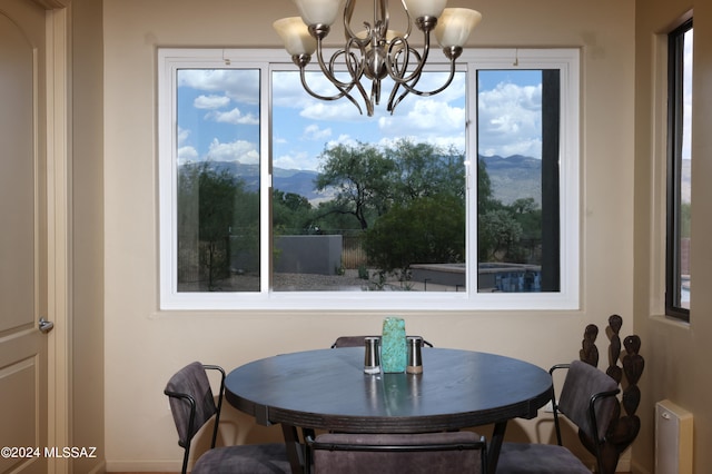 dining room featuring baseboards, a wealth of natural light, a mountain view, and a chandelier