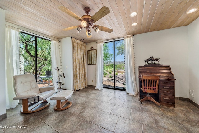 living area with ceiling fan, a healthy amount of sunlight, and wood ceiling