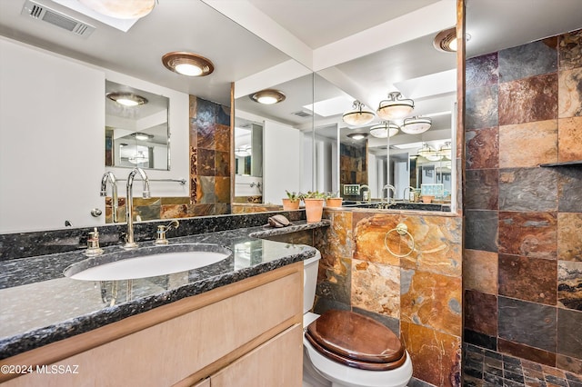 bathroom featuring a shower, vanity, and toilet