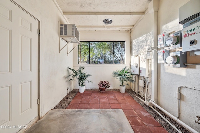 unfurnished sunroom featuring beamed ceiling and a wall mounted AC