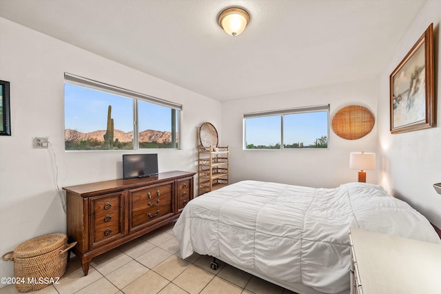 bedroom with multiple windows and light tile patterned floors