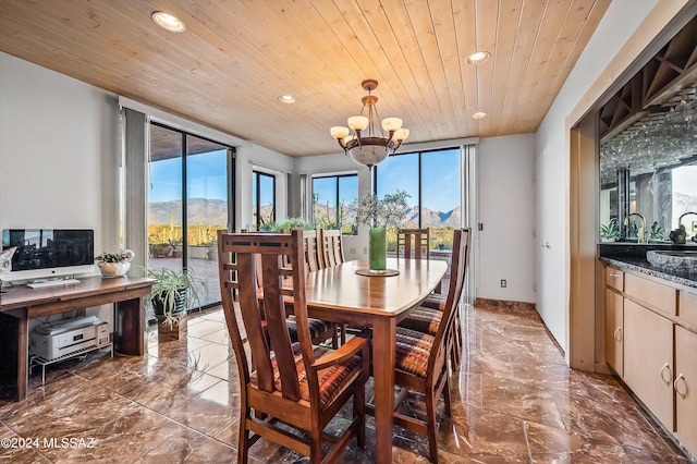 dining room with a mountain view, wood ceiling, sink, and an inviting chandelier